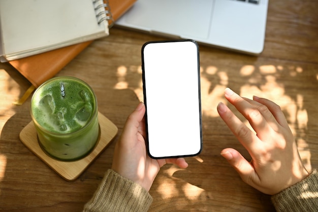 Top view of a woman using her smartphone while remote working and relaxing at a cafe