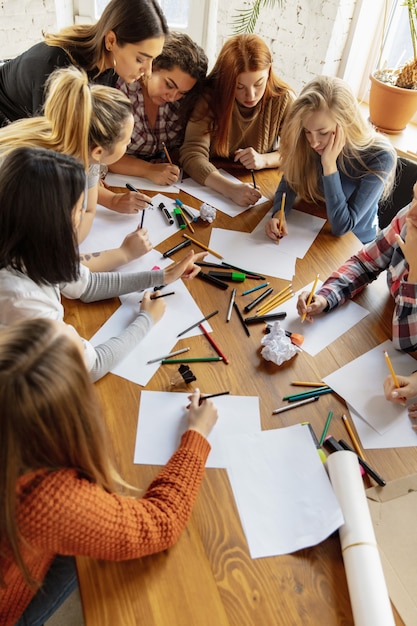 Top view of women preparing poster about women's rights and equality at the office. Caucasian businesswomen or office workers have meeting about problem in workplace, male pressure and harassment.