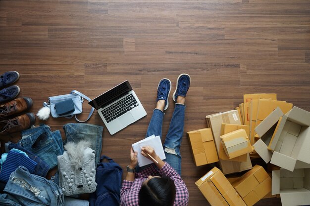 Top view of women write a notebook on wooden floor with, Selling online ideas concept