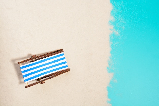 Top view of wooden beach chair on beach.