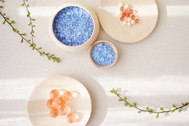 Top view of wooden bowls with bath salt and green sprigs