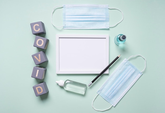 Top view of wooden cubes with covid and frame next to medical masks