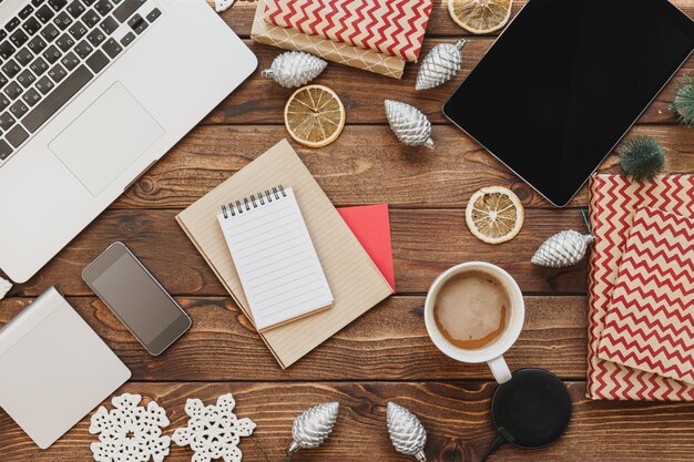 Top view of a wooden desktop with computer with office supplies and christmas decorations