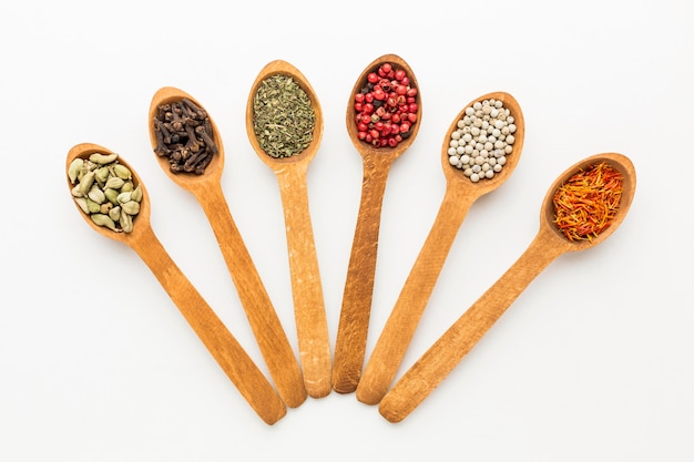 Top view wooden spoons with variety of spices