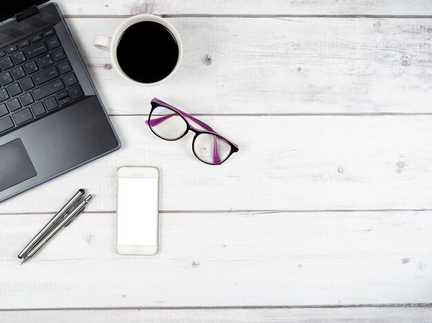 Top view workspace laptop glasses coffee cup and two silver pen with smartphone copy space