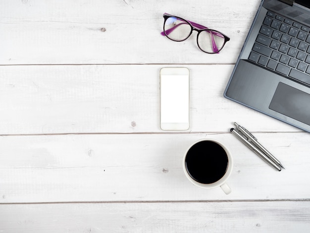 Top view workspace laptop glasses coffee cup and two silver pen with smartphone copy space