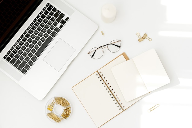 Top view workspace mockup on white with notebook, accessories, candle and glasses