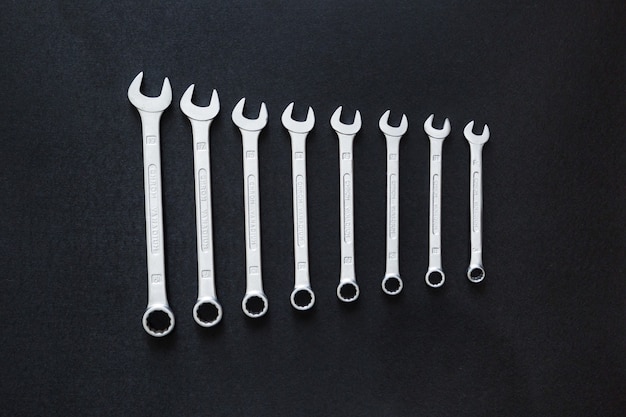 Top view of wrenches combination for car repair on black background, flat lay