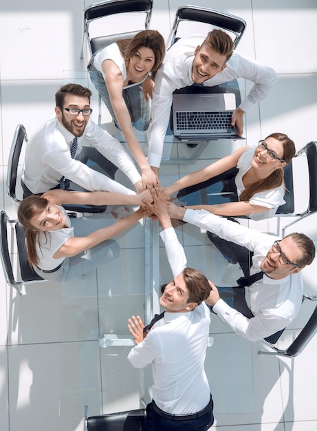 Photo top view of young business people putting their hands togetherunity and teamwork concept