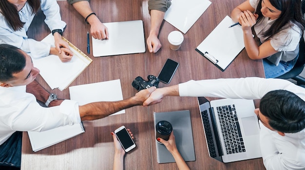 Top view of young business people that working together with documents and laptop in the modern office.