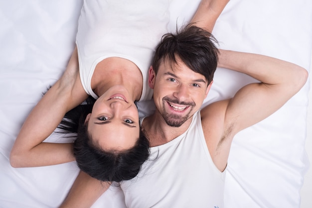 Top view of a young happy couple in bed.