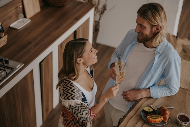 Top view of young loving couple toasting with champagne and smiling while celebrating anniversary