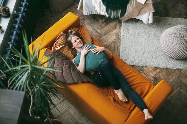 Photo top view of young woman lying on sofa at home