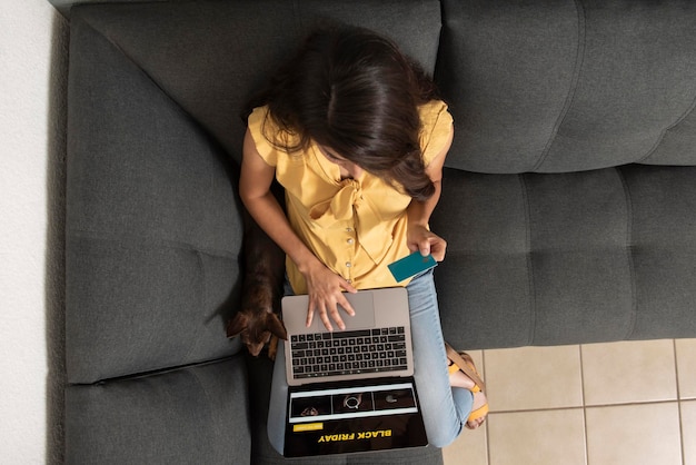 Top view of young woman shopping online from her laptop from home