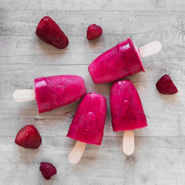 Top view of yummy popsicles with strawberries