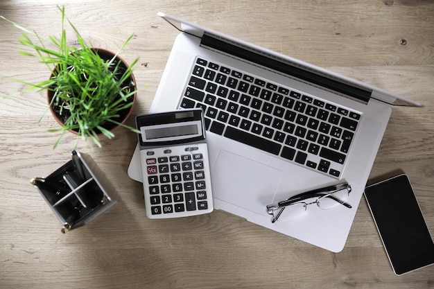 Top viewlaptop calculator and smartphone on a wooden table bu