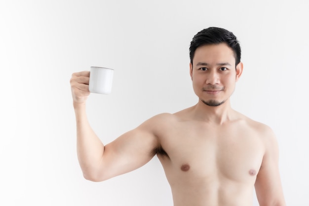 Topless healthy man drinks the healthy coffee on isolated wall.