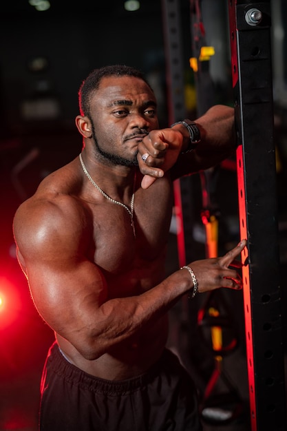 Topless macho bodybuilder posing in gym Strong shirtless muscular handsome man