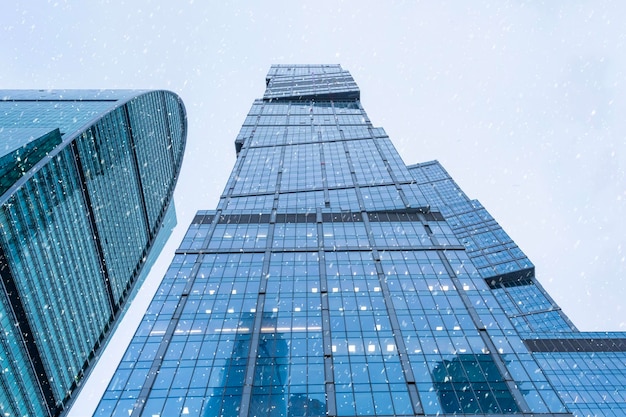 The tops of modern corporate buildings in snowfall Low angle view of skyscrapers