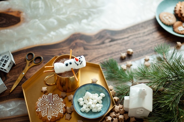 Topview table with christmas decor snowmen from marshmallows decorated with sugar glaze gingerbread ...