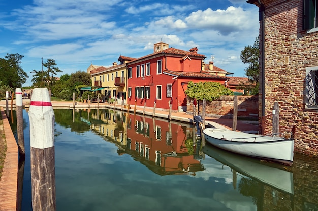 Torcello, Venice. Colorful houses on Torcello island, canal and boats. Summer, Italy