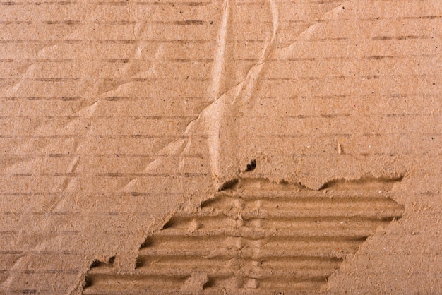 Torn edges corrugated brown cardboard sheet of paper texture