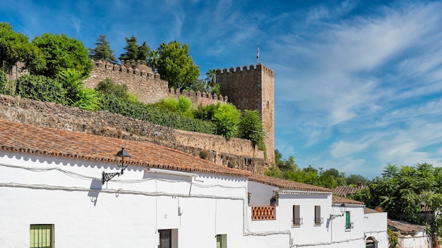 Torreon y muralla almenada del alcazar templario sobre las casas blancas de la villa de Jerez de los Caballeros Espana