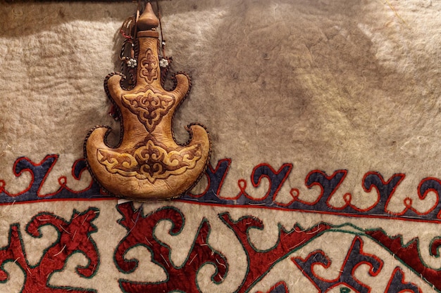 Torsyk Kazakh national container for drinks with turkish ornament on the background of a carpet with central asian patterns