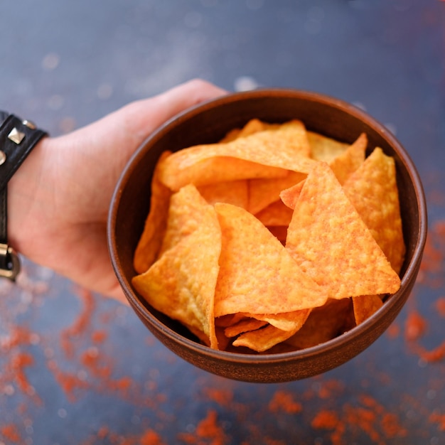 Tortilla nacho chips recipe natural fried crisps woman hand holding a bowl full of crunchy spicy triangular slices