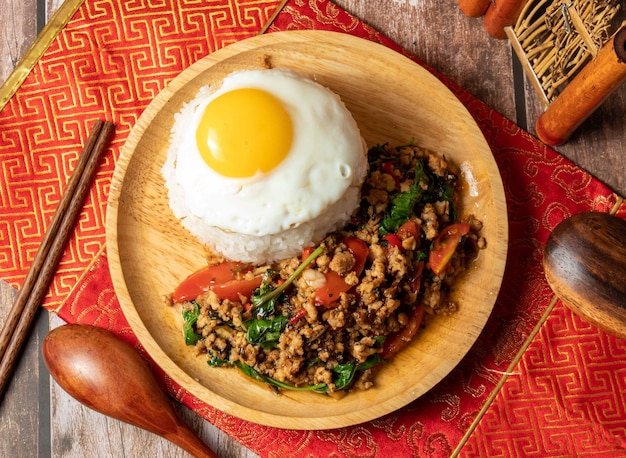 Tossed Chicken Rice with sunny egg served in wooden dish isolated on table side view of taiwan food