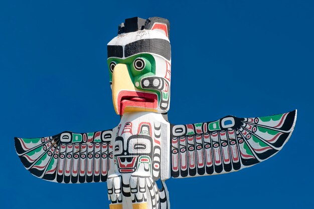 A totem wood pole in the blue cloudy background