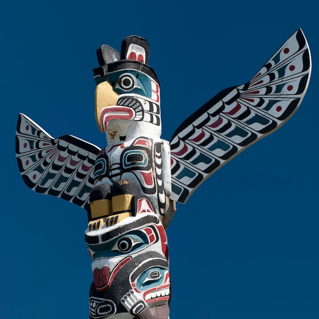 A totem wood pole in the blue cloudy background