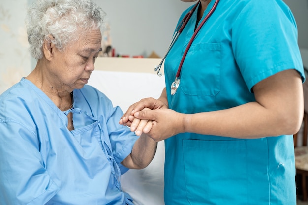 Touching Asian senior woman patient with love care helping encourage and empathy