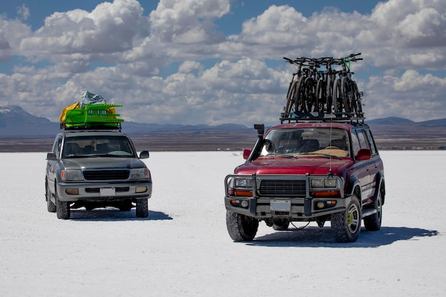 Tour in two cars off-road vehicles with submerged bicycles on lake Salar de Uyuni