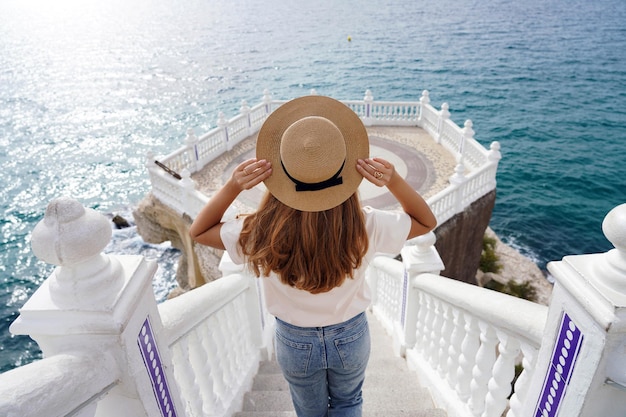 Tourism in Alicante, Spain. Back view of traveler girl descends stairs of Balcon del Mediterraneo in Benidorm, Alicante, Spain. Young female tourist visiting southern Europe.