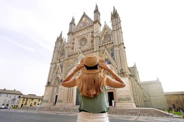 Tourism in Italy Young woman enjoying view the well reserved Cathedral of Orvieto Umbria Italy