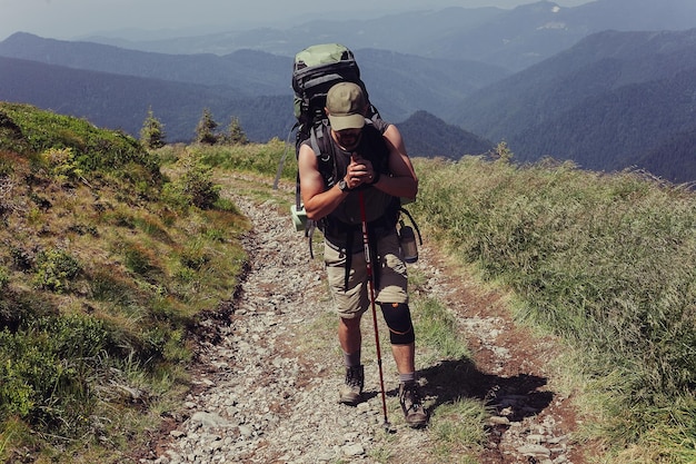 Tourism mountains lifestyle nature people selfie concept  medicine crutch and leg fixed in immobilize achieved mountain peak Man has fixed broken leg immobilizer bellow man Spring sunny day