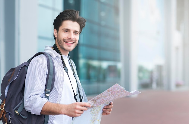 Tourism vacation travelling concept Happy tourist holding map standing near airport