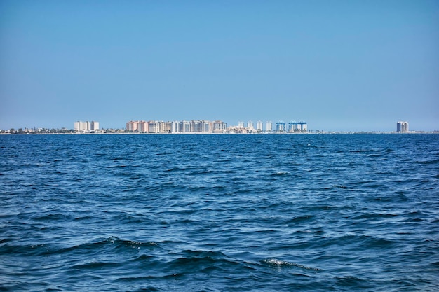 Tourist area of apartments in La Manga del Mar Menor seen from inside said sea on a clear blue sky day