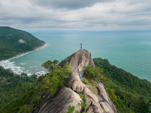 Tourist couple climbing the bottle view point Koh Phangan Island Thailand