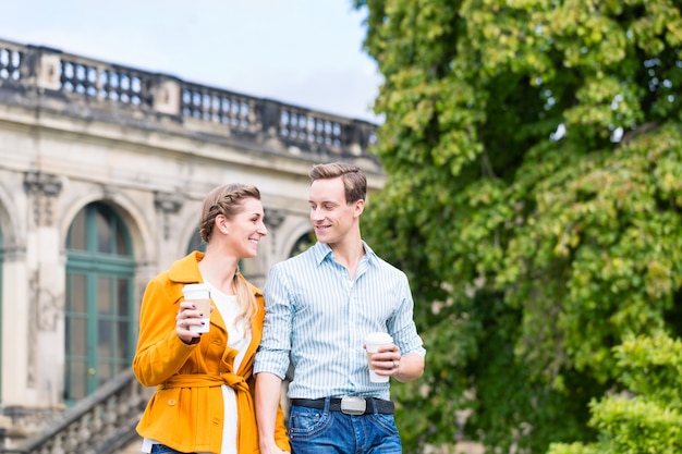 Tourist couple in Dresden having walk at Zwinger with coffee