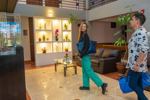 Tourist couple entering the reception of a luxury hotel, in a tourist city.