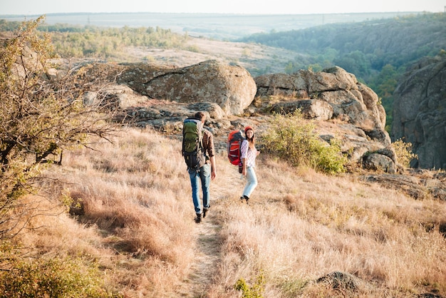 Tourist couple on mountain road. back view