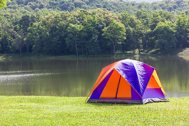 Tourist dome tent camping in forest camping site at lake side 