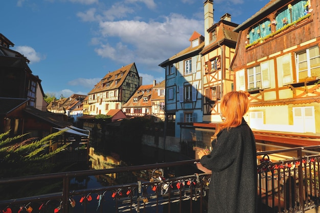 Tourist enjoy the view of Traditional halftimbered houses on the river bank in Colmar Alsace rigion France