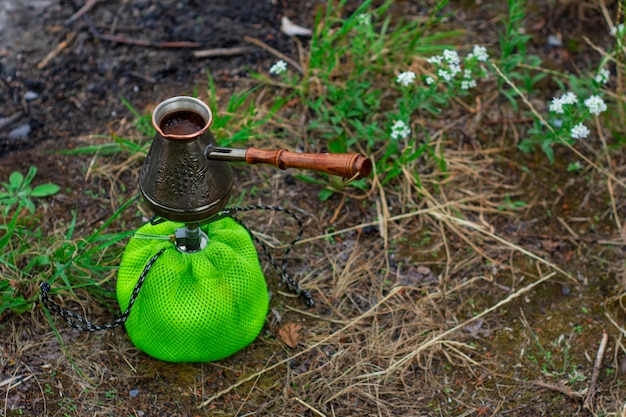 Tourist gas burner with a cezve for coffee against the backdrop of nature