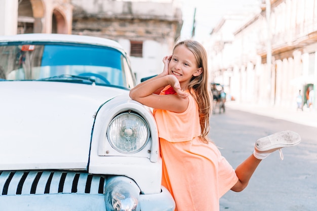 Tourist girl in popular area in Havana, Cuba. Young kid traveler smiling