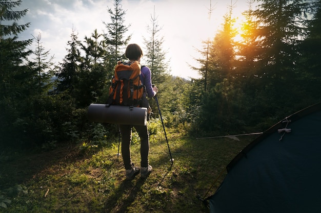 Tourist girl stands near the tent in the  mountain. Carpathians,  Ukraine.