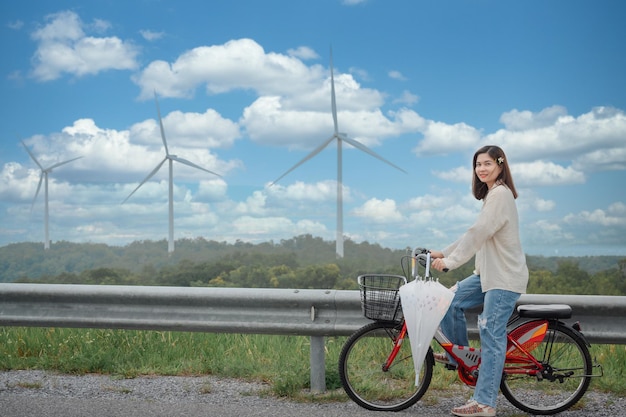 Tourist girl Visit the windmill fields at the renewable power station The background is a wind turbine generating electricity on a beautiful mountain