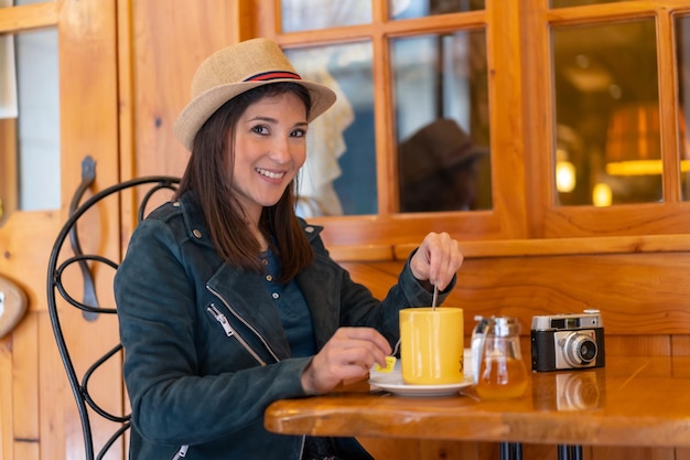 A tourist girl with a photo camera drinking tea on a cafe terrace spring summer vacation travel